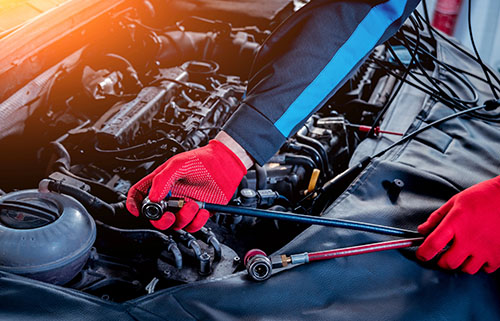 Mobile mechanic in Albuquerque performing engine diagnostics and AC repair under a car hood