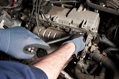 Mobile mechanic performing a car tune-up in Albuquerque, replacing spark plugs and filters on-site